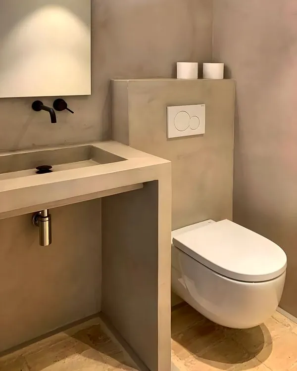 Baño con lavabo de obra y suelo de barro · Instagram @morales_obresiserveis