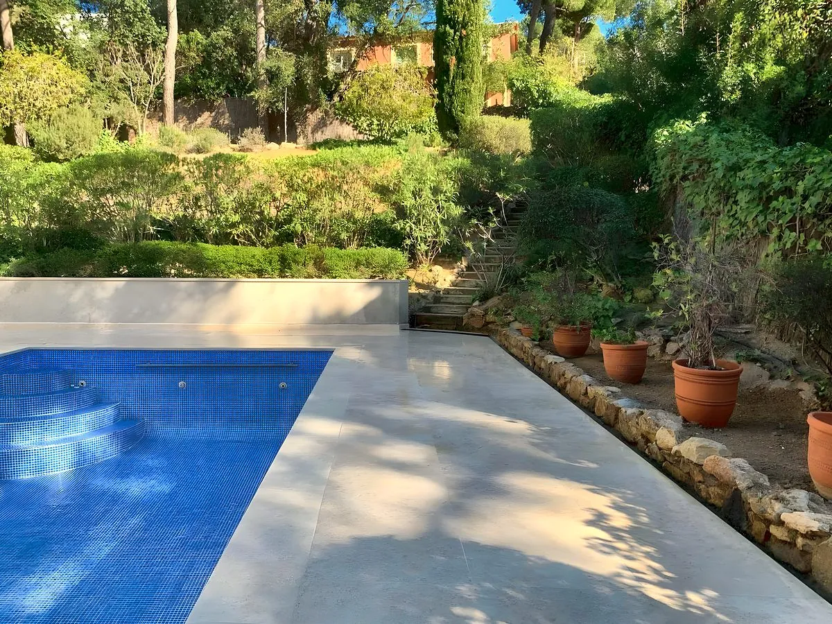Piscina de gresite azul con coronación de piedra